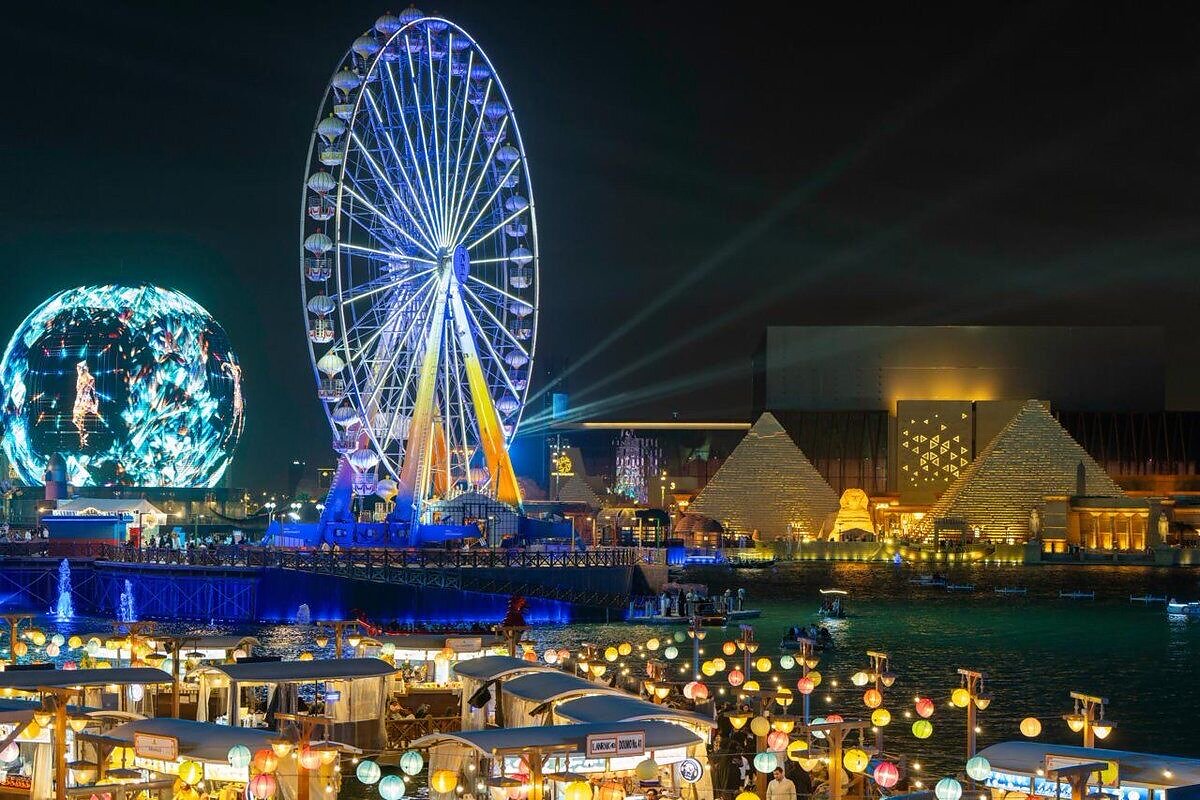 Illuminated Ferris wheel and entertainment venues at night in Saudi Arabia