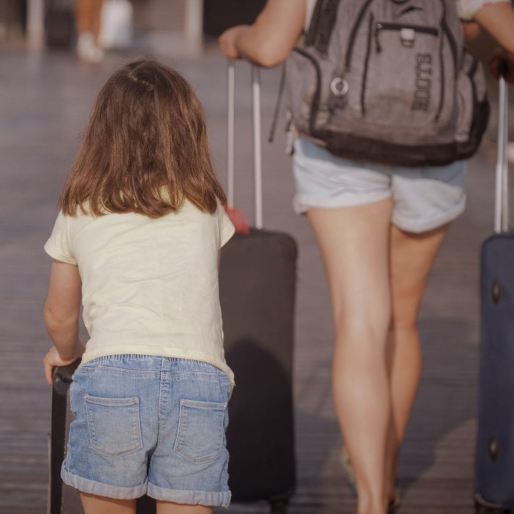 Mother and child walking with luggage