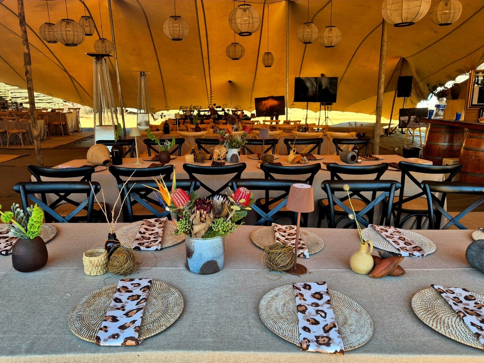 Long dining tables set inside a lantern-lit tent at the Chiefs camp at Mongena Private Game Reserve