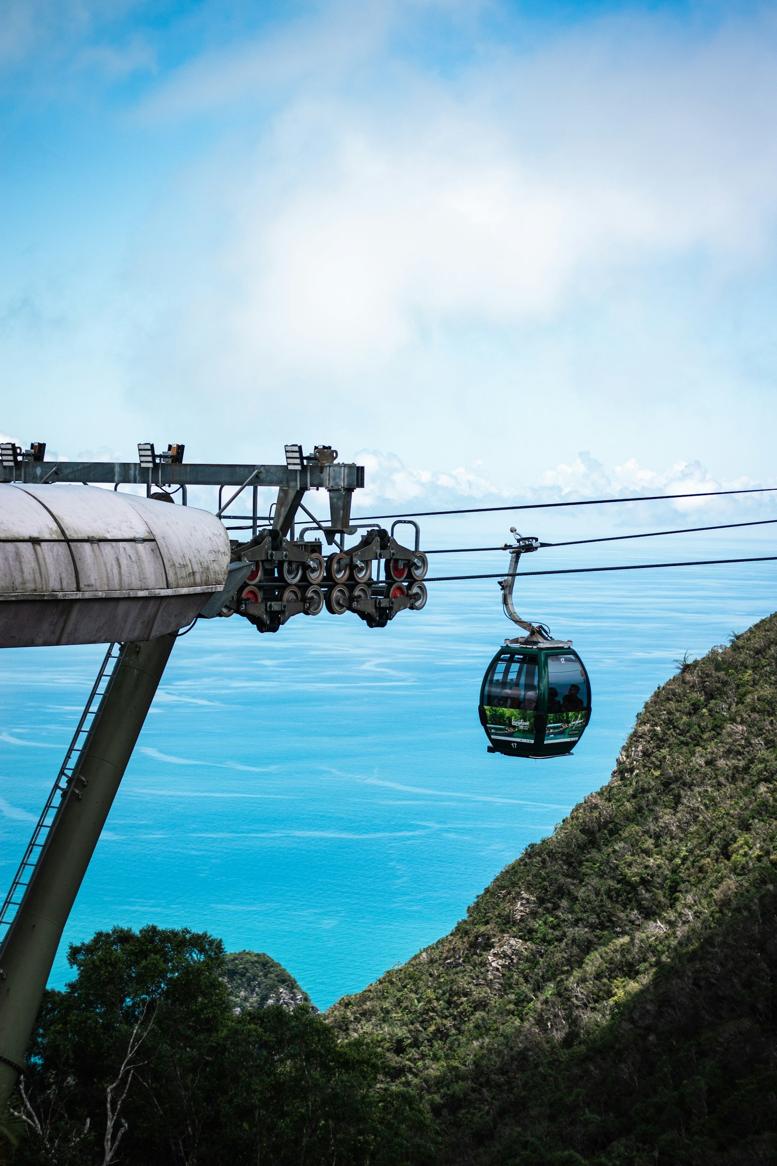Cable car rising above forested hills with the sea beyond on Langkawi, Malaysia