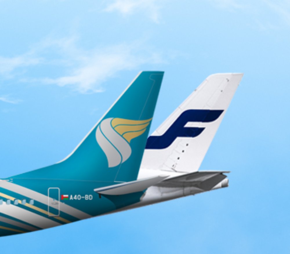 Tails of an Oman Air aircraft and a Finnair aircraft side by side