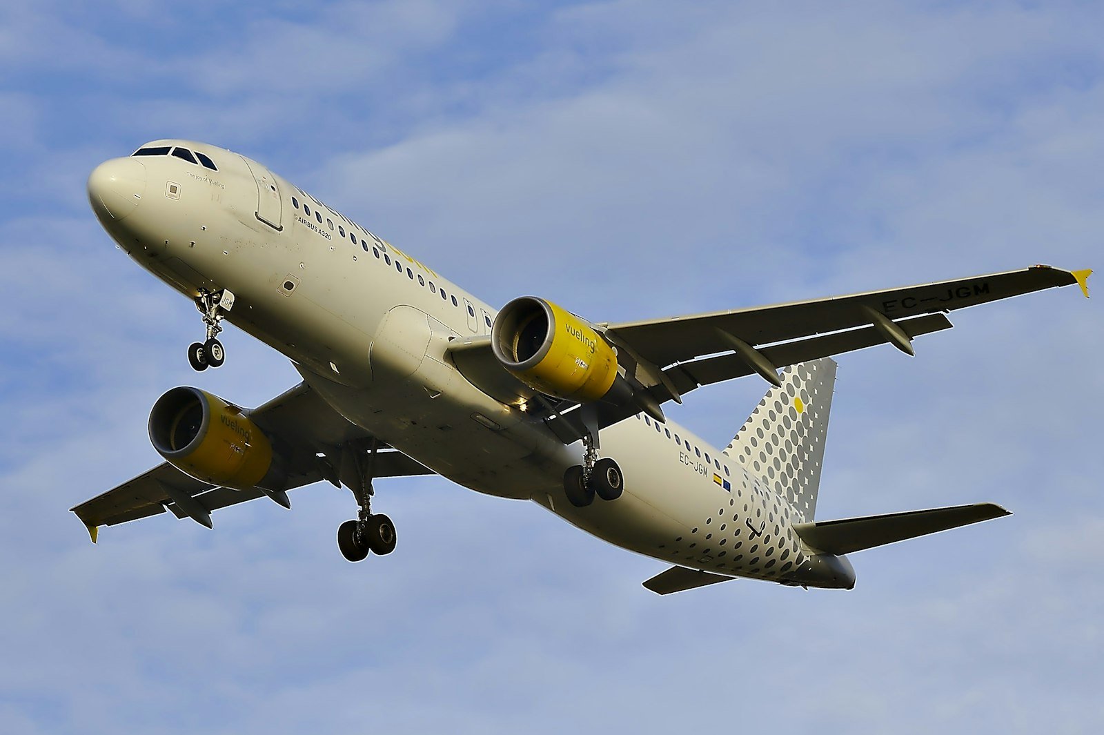 White passenger aircraft in flight over a cloudy sky